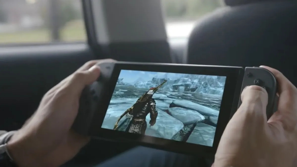 A man plays a Switch in a car